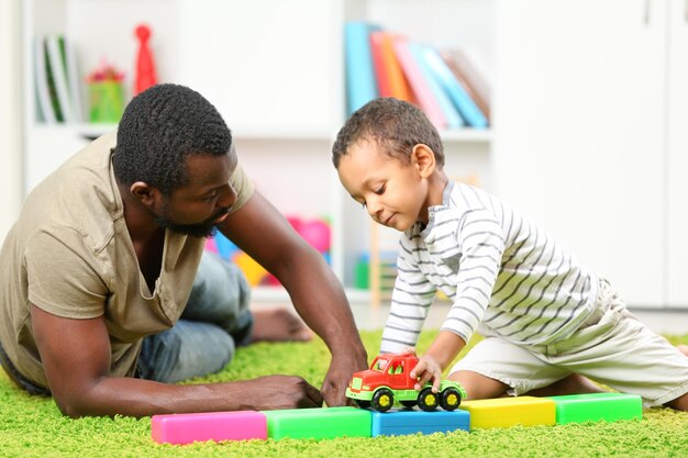 Pai e filho pagando no quarto das crianças