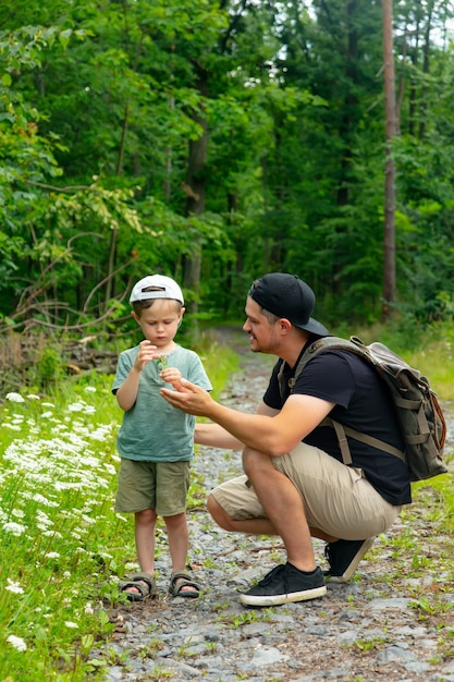 Pai e filho passam um tempo juntos na floresta de verão