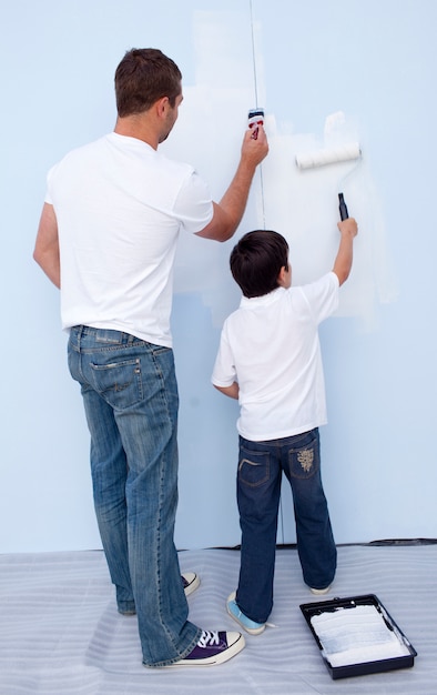 Pai e filho pintando uma parede