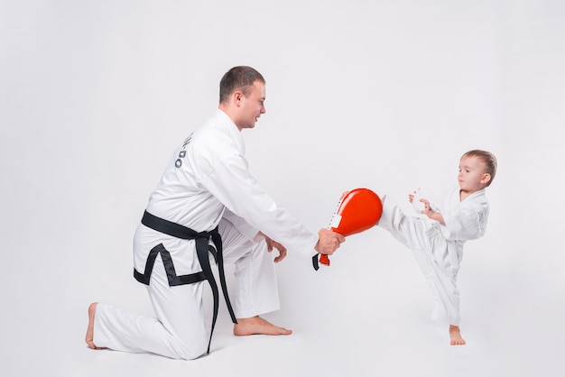 Pai e filho praticando taekwondo em branco