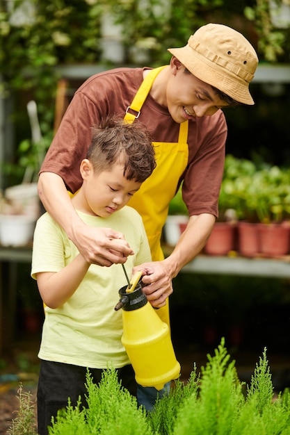 Pai e filho regando plantas