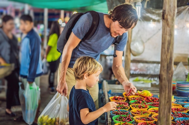 Pai e filho são turistas no mercado de comida asiática de rua ambulante