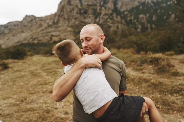 Pai e filho se abraçando em caminhada nas montanhas