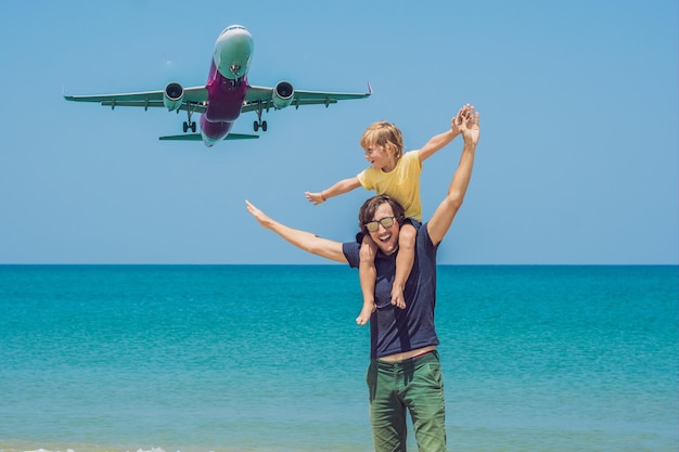 Pai e filho se divertem na praia observando os aviões pousando. Viajando em um avião com o conceito de crianças