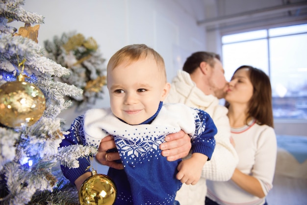 Pai e filho se divertindo e brincando juntos perto de árvore de natal.