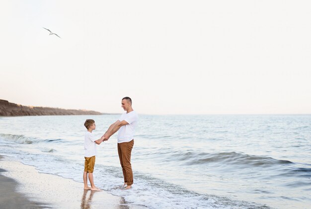 Pai e filho se divertindo na costa do mar. Férias em família. Amizade