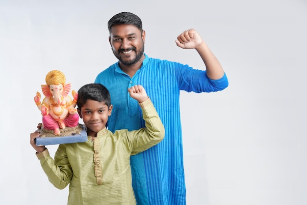 Pai e filho segurando um ídolo do senhor Ganesha