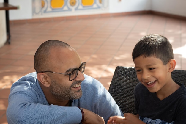 Pai e filho sorridente sentados ao ar livre