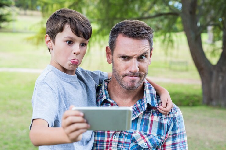 Foto pai e filho tomando um selfie no parque