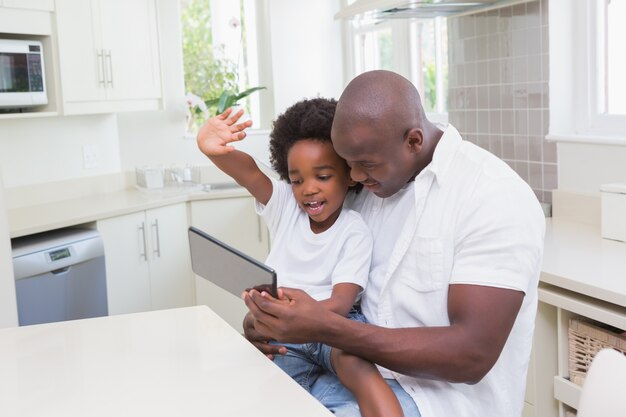 Pai e filho, usando o laptop no sofá