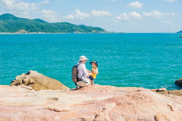 Pai e filho viajantes na capa de hon chong, pedra de jardim, destinos turísticos populares em nha trang. vietnã