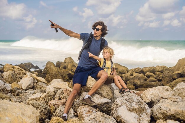 Pai e filho viajantes na incrível Melasti Beach com água turquesa Bali Island Indonésia Viajando com o conceito de crianças