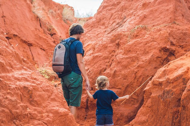 Pai e filho viajantes no desfiladeiro vermelho perto de Mui Ne, sul do Vietnã. Viajar com o conceito de crianças.