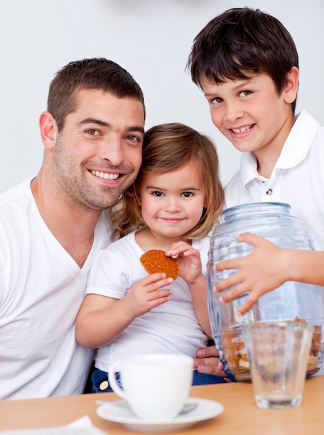 Foto pai e filhos comendo biscoitos com leite