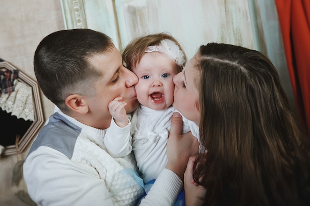 Pai e mãe beijam o bebê. Conceito de família.