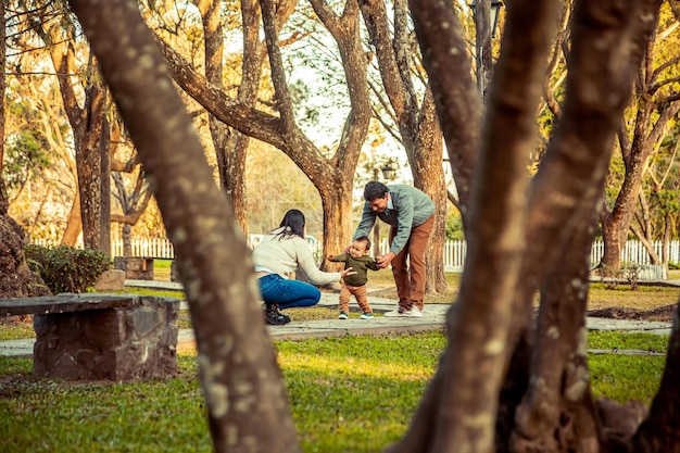 Pai e mãe com seu filho pequeno em um parque ao ar livre