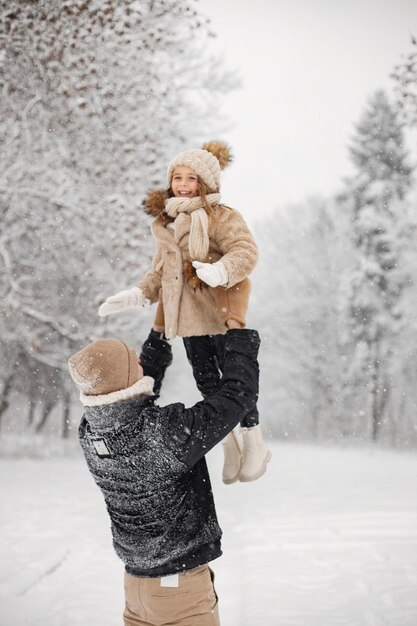 Pai e sua filha brincando ao ar livre no dia de inverno