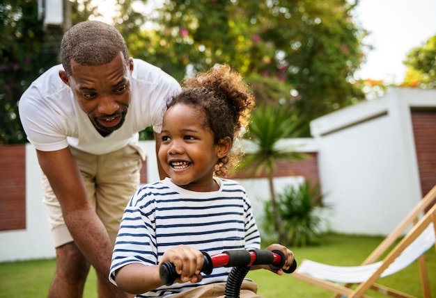 Pai ensina filha a andar de bicicleta