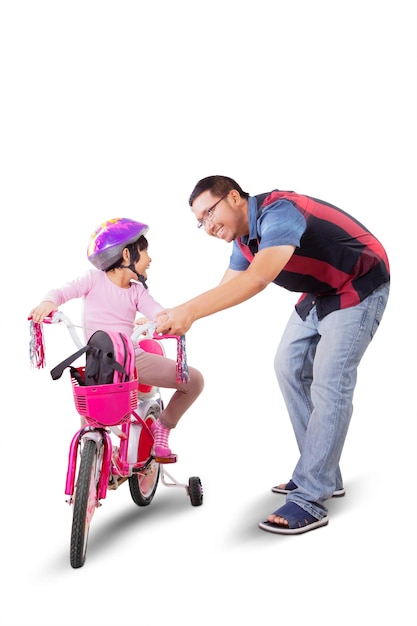 Pai ensinando filha a andar de bicicleta no estúdio