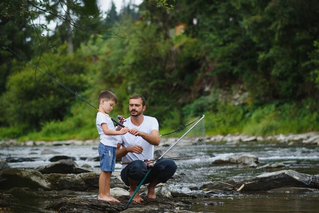 Pai ensinando filho a pescar no rio