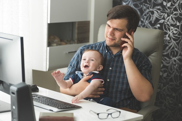 Pai falando ao telefone e cuidando de seu bebê