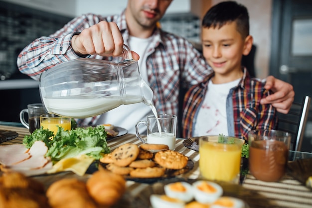 Pai fazendo café da manhã para o filho em casa