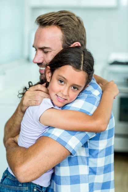 Pai feliz, abraçando a filha em casa