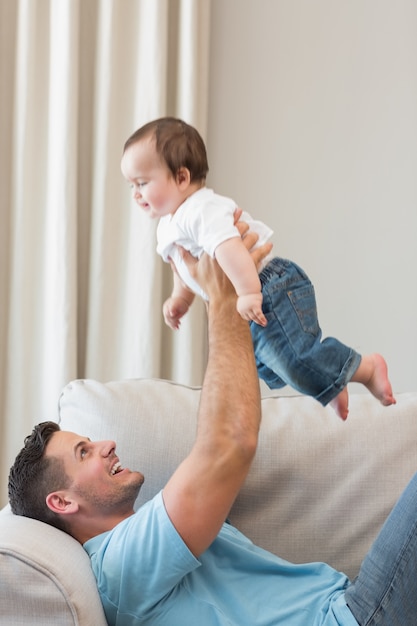 Pai feliz brincando com bebê fofo