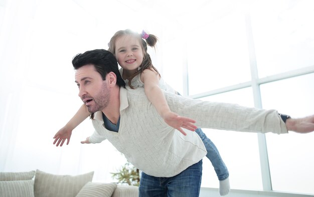 Pai feliz brincando com sua filha em casa o conceito de paternidade