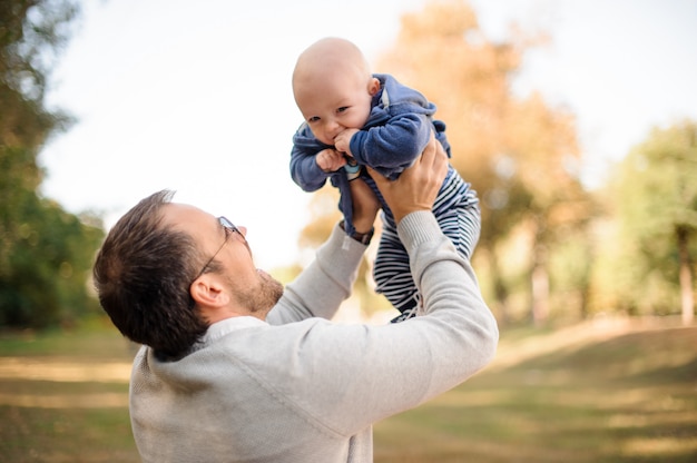 Pai feliz brincando com um filho bebê fofo