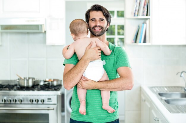 Pai feliz, carregando o filho na cozinha