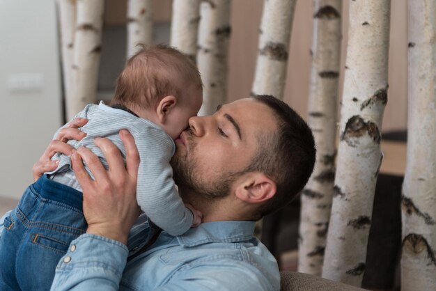 Pai feliz com bebê no sofá