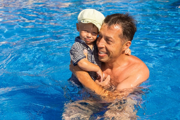 Pai feliz com criança brincando em uma piscina na natureza à beira-mar