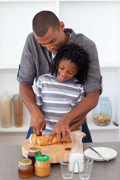 Pai feliz cortando pão com seu filho