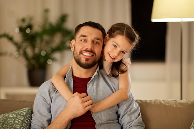 pai feliz e filha pequena abraçados em casa