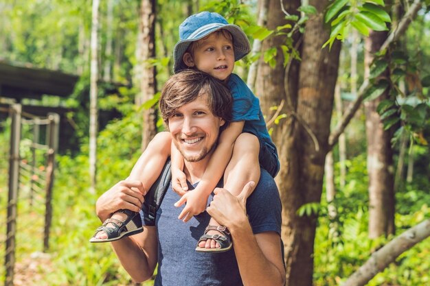 Pai feliz e filho andando no parque de verão. adoção e conceito de pessoas