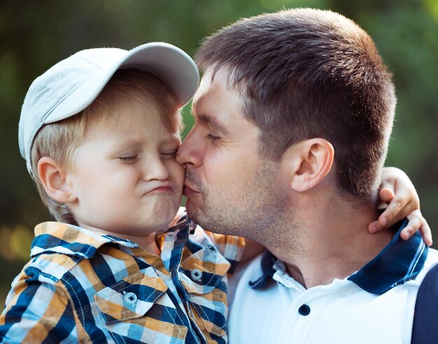 Foto pai feliz e seu filho bebê se divertindo no parque ao ar livre