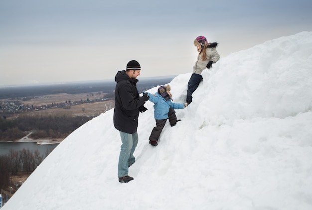 Pai, filho e filha na montanha de neve