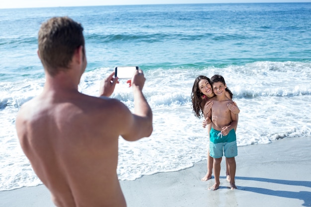 Pai fotografando esposa e filho felizes