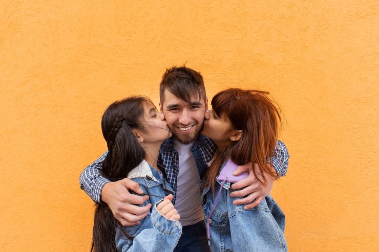 Foto pai jovem e feliz abraça os filhos, foto para o dia dos pais