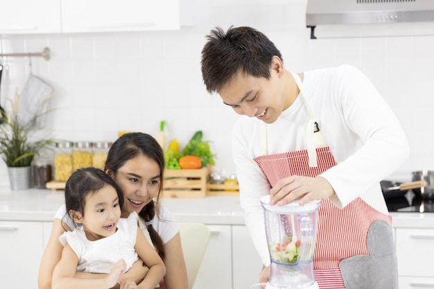 Pai, mãe e filha estão preparando o almoço