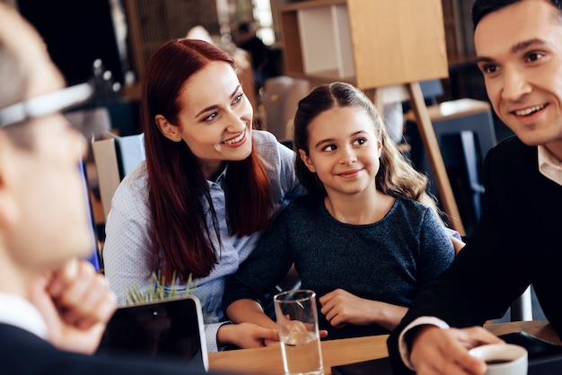 Pai, mãe e filha estão sentados no escritório do advogado.