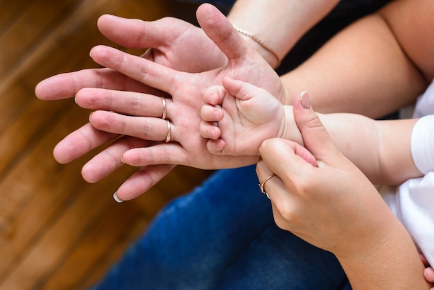 Pai, mãe e filho de mãos dadas