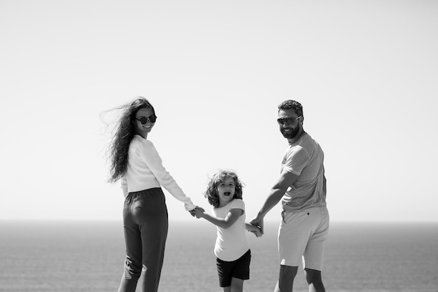 Pai mãe e filho na praia de verão na hora do pôr do sol conceito de família amigável e férias de verão