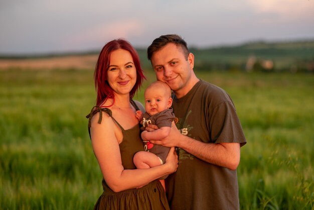 Foto pai, mãe e filho se divertem juntos em um campo de trigo