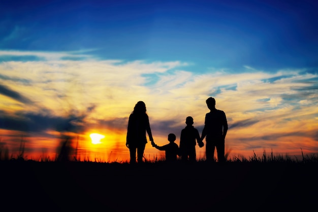 Foto pai, mãe e filhos as mãos em um fundo por do sol.