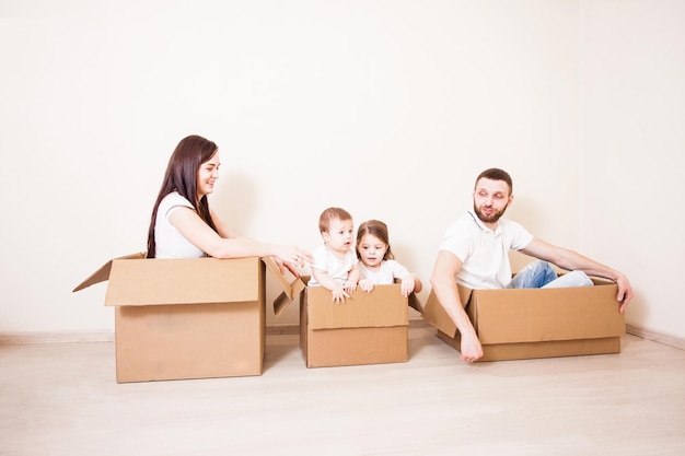 Pai, mãe e filhos se divertindo juntos. Conceito de entrega rápida ou dia de mudança de casa