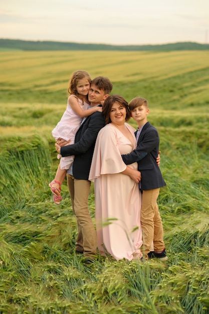 Pai mãe, filho e filha em um campo de trigo