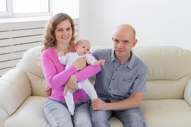 Pai, mãe segurando um bebê fofo dentro de casa