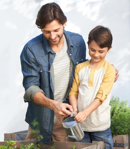 Foto pai menino e estufa com água para plantas vegetação e agricultura para o negócio da família pai e filho ensinar em estufa para cultivar vegetais orgânicos para vender sustentabilidade e jardinagem